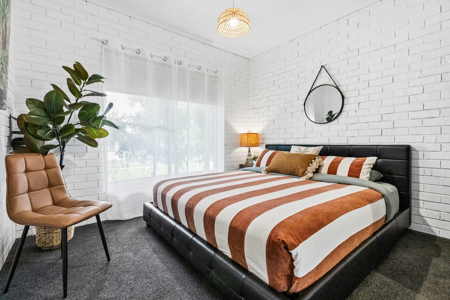 Bedroom with a broad window and white-painted brick walls