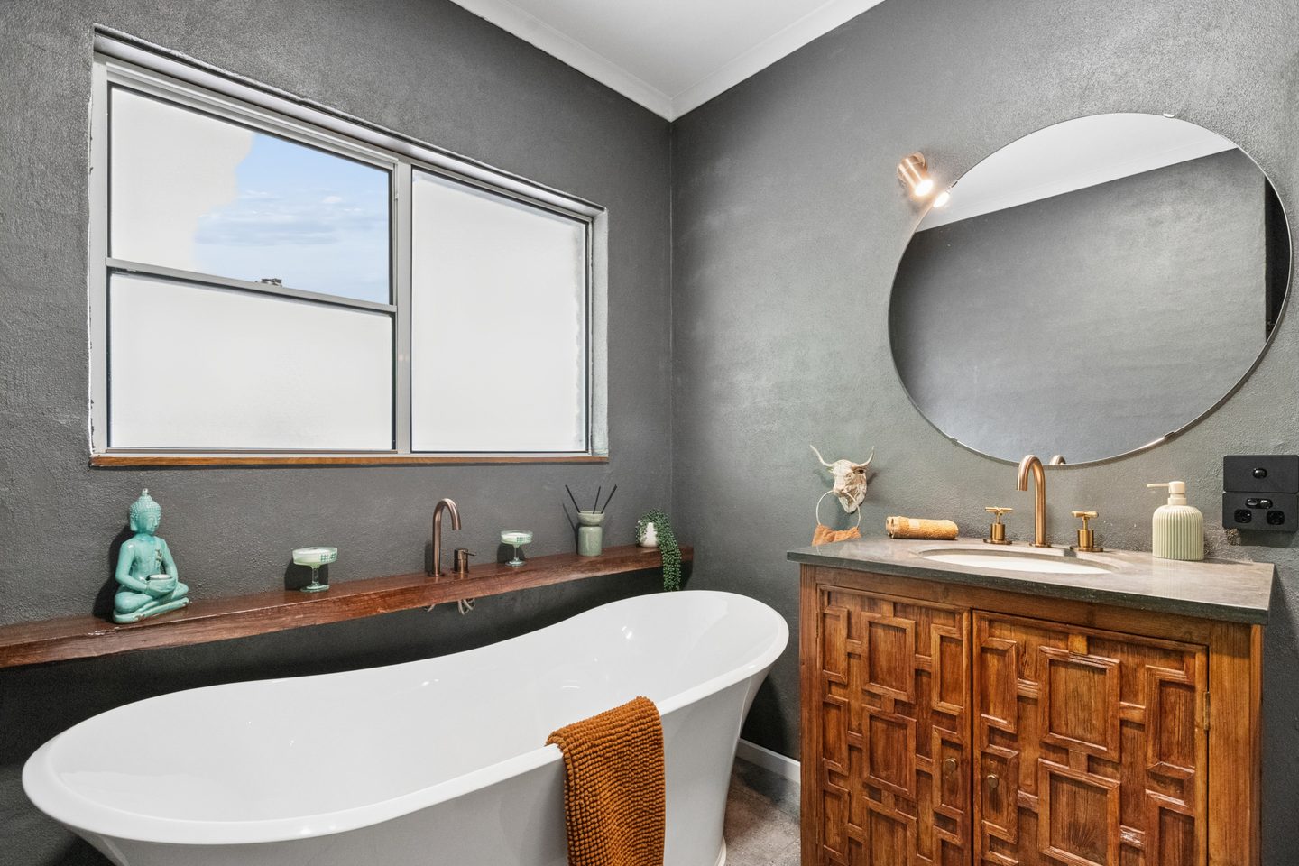 Freestanding bath beside the patterned vanity