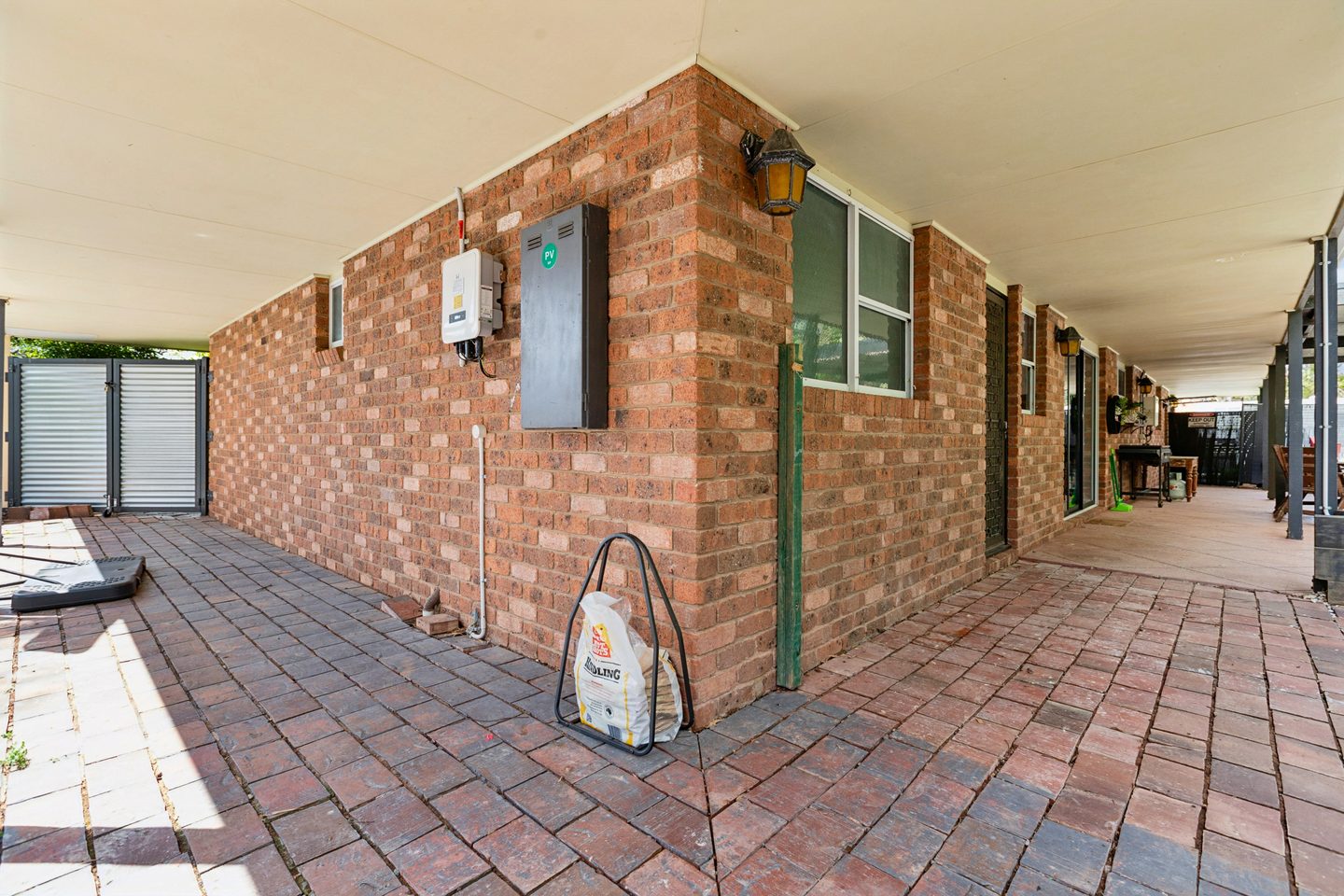 Covered brick-paved walkway beside the house
